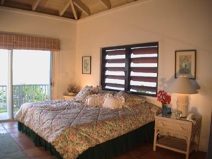 St John rental home Altamira bedroom with high ceilings, king sized bed and sliding glass door onto patio with views