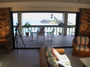 St John USVI Vacation Rental Soft Winds living room looks out to patio with dining table and hammock, and onto Caribbean ocean views