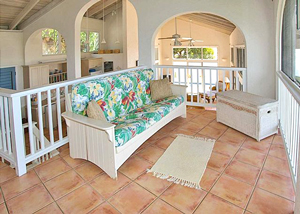 Guest room on second floor with wicker furniture and high ceilings